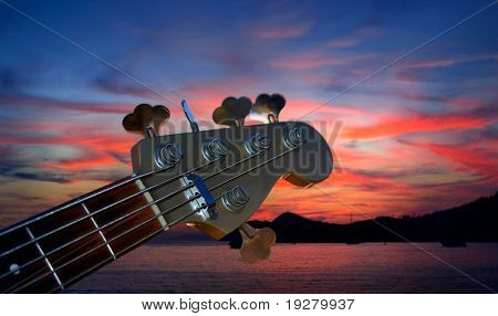 Juego de contrabajo en la oscuridad en el cielo rojo y el mar