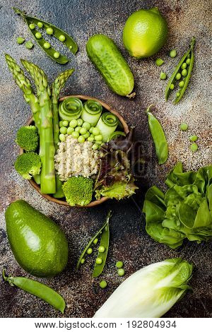 Vegan detox green Buddha bowl recipe with quinoa cucumber broccoli asparagus and sweet peas. Top view flat lay