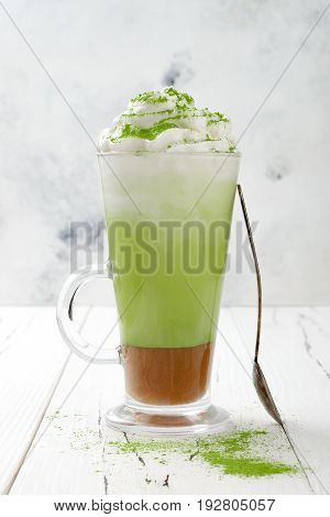 Matcha latte with salted caramel in tall glass.