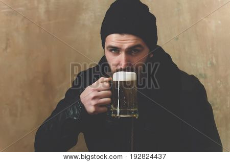 beer with foam in glass mug at bearded hipster or brutal man with long beard and moustache drinking Alcohol bad habits addictive lifestyle refresher convive
