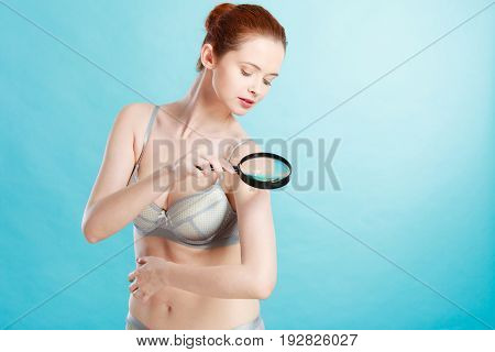 Woman Using Magnifying Glass To Examine Her Moles Skin