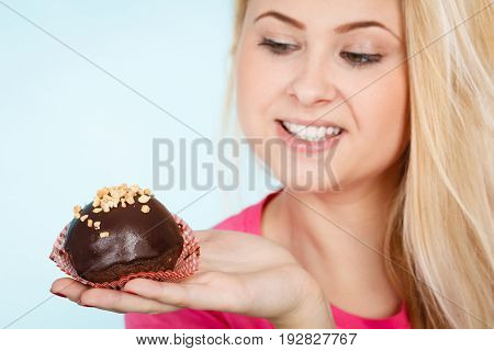 Woman Holding Chocolate Cupcake About To Bite