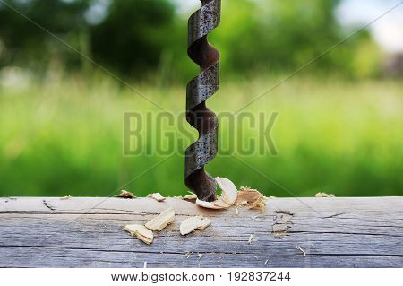 Metal spiral drill for making holes in logs when assembling a wooden frame and building a house.