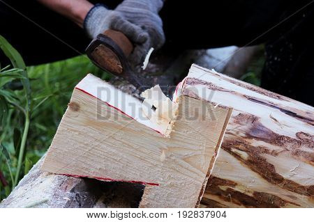 The worker collects a wooden frame with the help of an hacket during the construction of a house.