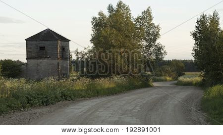 Rural dirt road and abandoned village house.
