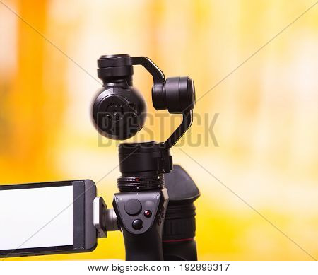 QUITO, ECUADOR- DECEMBER 22, 2017: Osmo Mobile gimbal, new generation of electronic stabilizer in a blurred forest background.