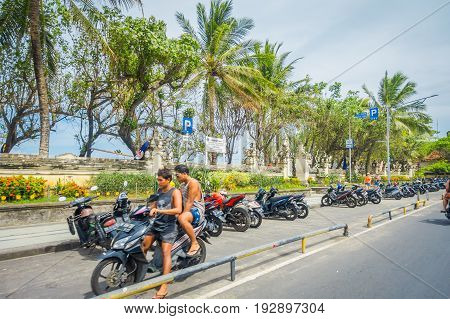 BALI- INDONESIA MARCH 08. 2017: Unidentified motorcyclist rides down the street. Legian's area. Legian is a suburban and beach area on the west coast of Bali.
