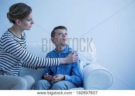 Mother and her autistic son sitting on the sofa