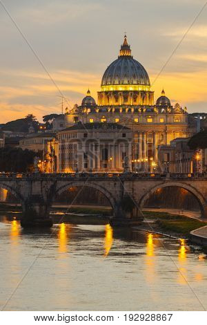Monumental St. Peters Basilica over Tiber  at twilight in Rome, Italy