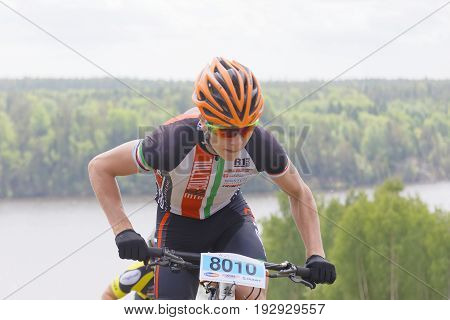 STOCKHOLM SWEDEN - JUNE 11 2017: Closeup of mountain bike cyclist lake and forest in the background at Lida Loop Mountain bike Race. June 11 2017 in Stockholm Sweden