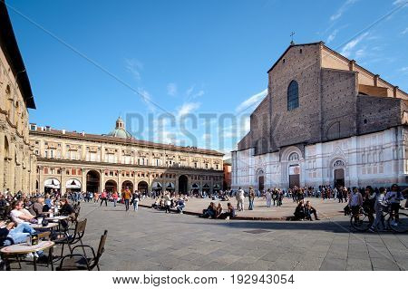 Bologna Italy - April 17 2017: Citizens and tourists on a sunny day walk and relax in Piazza Maggiore Bologna's main square in front of the church of San Petronio a place full of historic monuments and city center.