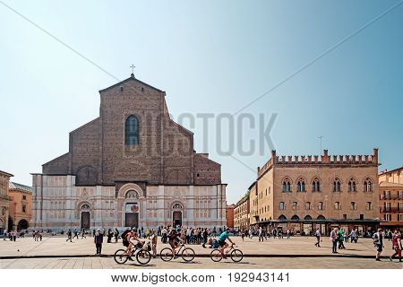 Bologna Italy - April 17 2017: Citizens and tourists on a sunny day walk and relax in Piazza Maggiore Bologna's main square in front of the church of San Petronio a place full of historic monuments and city center.