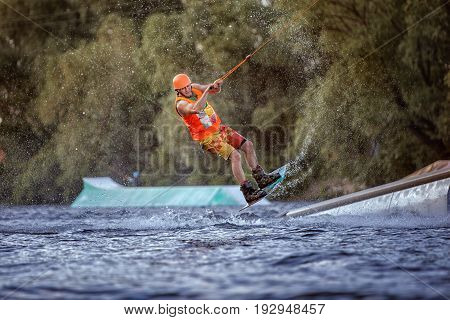 Man jumps on the water on a wakeboard he is an extreme sportsman.