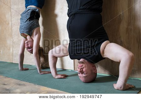 People Handstand push-up workout at gym, pushups updide down near the wall