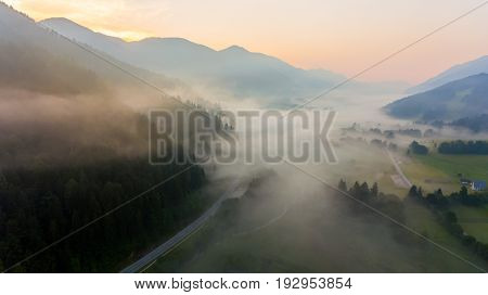 Aerial view mist hovering across a valley. Natural park Zelenci, Slovenia.