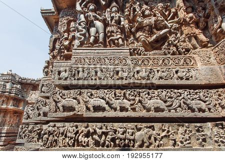 Dancing Hindu gods Shiva Lord and animals on stone wall with old relief. 12th centur Hindu Hoysaleshwara temple in Halebidu, India.