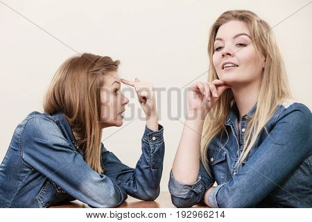 Two women having argue mocking up being mad at each other. Female telling off ignorance coversation concept.