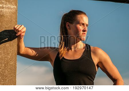 Fierce woman in sun framed by concrete doorway