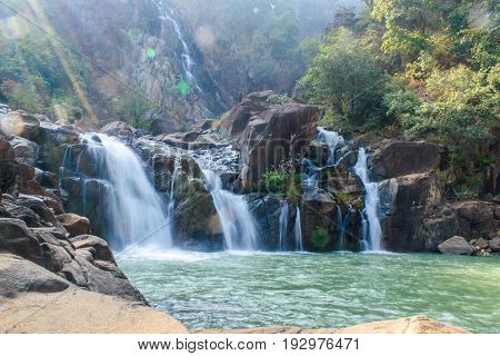 Lodh waterfall with sun rays in Jharkhand,India. Lens flare and light leak.