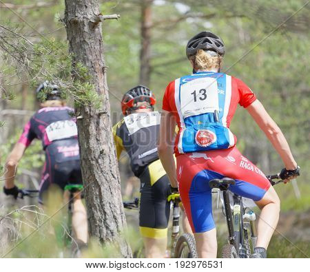 STOCKHOLM SWEDEN - JUNE 11 2017: Rear view of group of mountain bike cyclists in the forest at Lida Loop Mountain bike Race. June 11 2017 in Stockholm Sweden