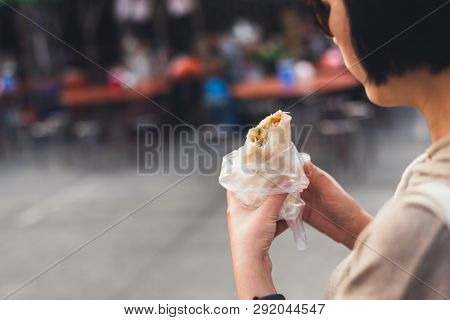 woman eat traditional Taiwanese snack of spring roll