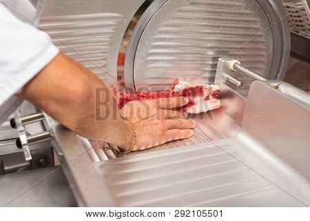 Hand Of Butcher Using Slicer Machine In Butcher Shop