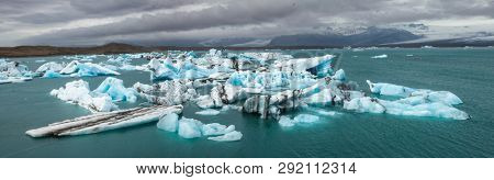 Panoramic view of melting icebergs floating in the Jokulsarlon glacial lagoon, a popular travel destination and one of the natural wonders of Iceland  Breidamerkurjokull glacier tongue