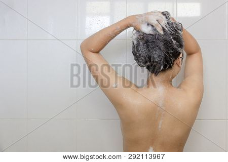 Young Asian Woman Taking A Shower And Washing Hair In White Bathroom