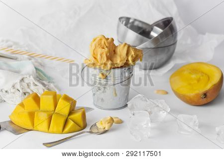 Mango Ice Cream In A Metal Mini Bucket Decorated With Sliced Mango Cubes On White Background