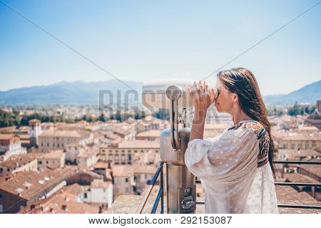 Girl Looking At Coin Operated Binocular On Terrace At Small Town In Tuscany