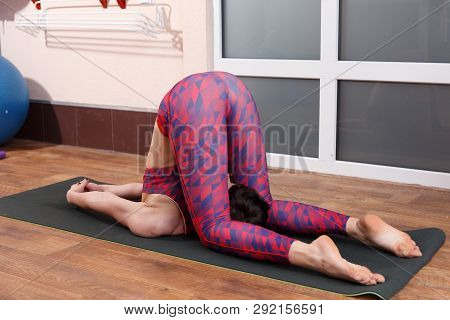 Young Sporty Woman Practicing Yoga, Doing Mahamudra Stretching Position In A Fitnes Club