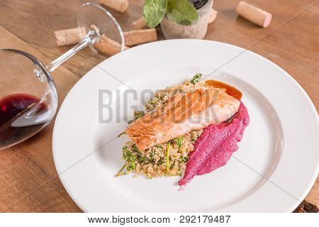 Salted Salmon In Butter With Quinoa And Violet Sauce, Served In A White Plate. Decorated With Corks 