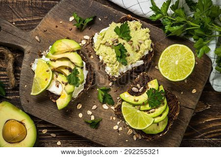 Sandwiches With Avocado And Cream Cheese With Grain Bread. Dark Wooden Background, Top View.