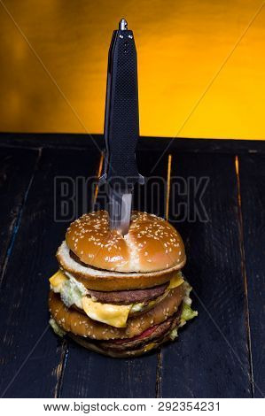 Burger with meat pierced with a knife. View of the burger from above. Top.