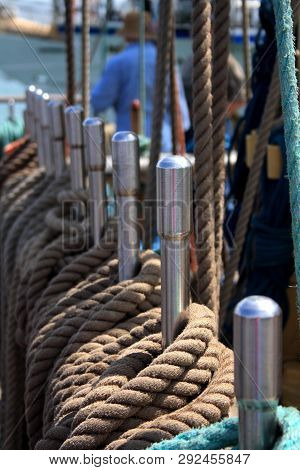 Ship Brown Ropes On The Rails With A Man On The Back Scene And Sea.