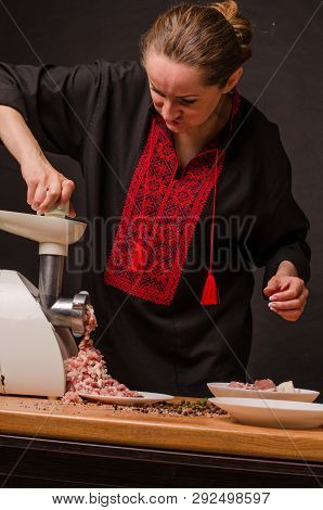 Woman Using Grinder For Preparation Of Minced Meat In Kitchen