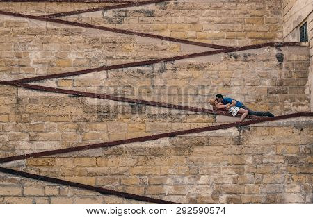 Man Kissing Woman Laying On The City Walls, Old City Of The Three Cities, Malta