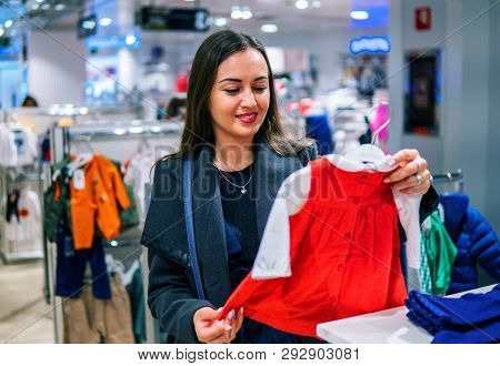 Customer Woman Choosing Baby Clothes In The Shop