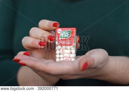 Young Girl Holds Tic-tac Hard Mints Pack With Coca-cola Taste. Tic Tac Is A Brand Of Small Hard Mint