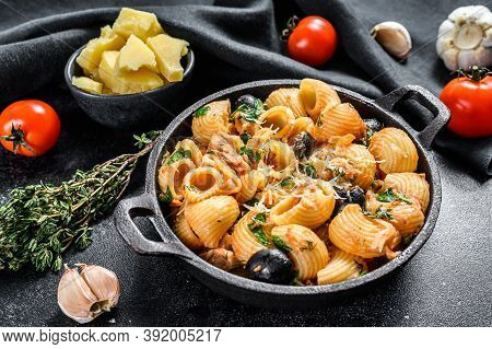 Conchiglie Rigate Pasta Puttanesca With Anchovies, Tomatoes, Garlic And Black Olives. Black Backgrou