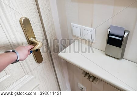 Female Hand Opening Secure Hotel Door From Inside. Closeup View Of A Security Key Card That Controls