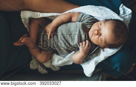 Upper View Photo Of A Newborn Caucasian Girl Sleeping While Held By Her Mother