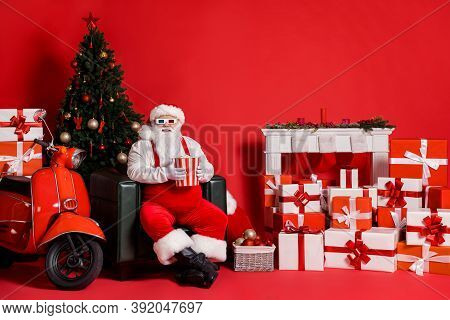 Full Body Photo Of White Hair Santa Claus Hold Pop Corn Box Sit Chair Isolated On Red Bright Color B