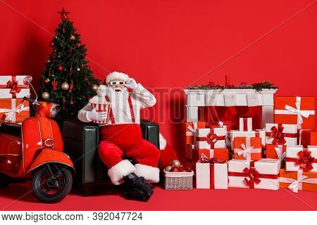 Full Size Photo Of White Hair Santa Claus Hold Pop Corn Box Sit Chair Isolated On Red Bright Color B