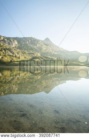 Scenic Bettmer Lake Near Fiesch In Wallis, Switzerland. Reflection On The Lake At Sunrise