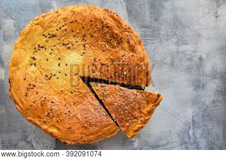 Freshly Baked Traditional Meat Pie On The Background Of A Concrete Table. Top View, Place For Text.\