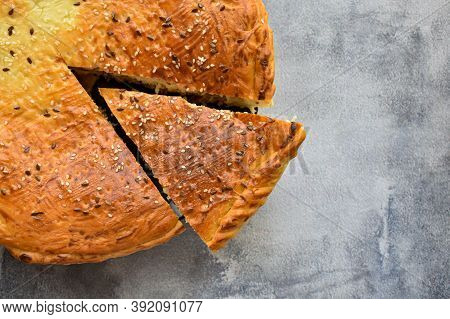 Freshly baked traditional meat pie on the background of a concrete table. Top view, place for text.
