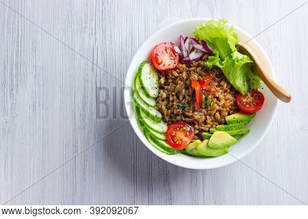 Bowl With Spelt Or Farro, Tomatoes, Cucumbers, Avocado And Onion With Salad Leaves, Herbs And Chia S