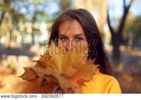 Beautiful Caucasian Young Woman Walking And Having Fun Outdoors In Autumn Time. Bright Yeallow Color