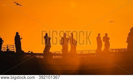 Sculptures Of Saints In Vatican, Silhouette On The Orange Background, Panorama